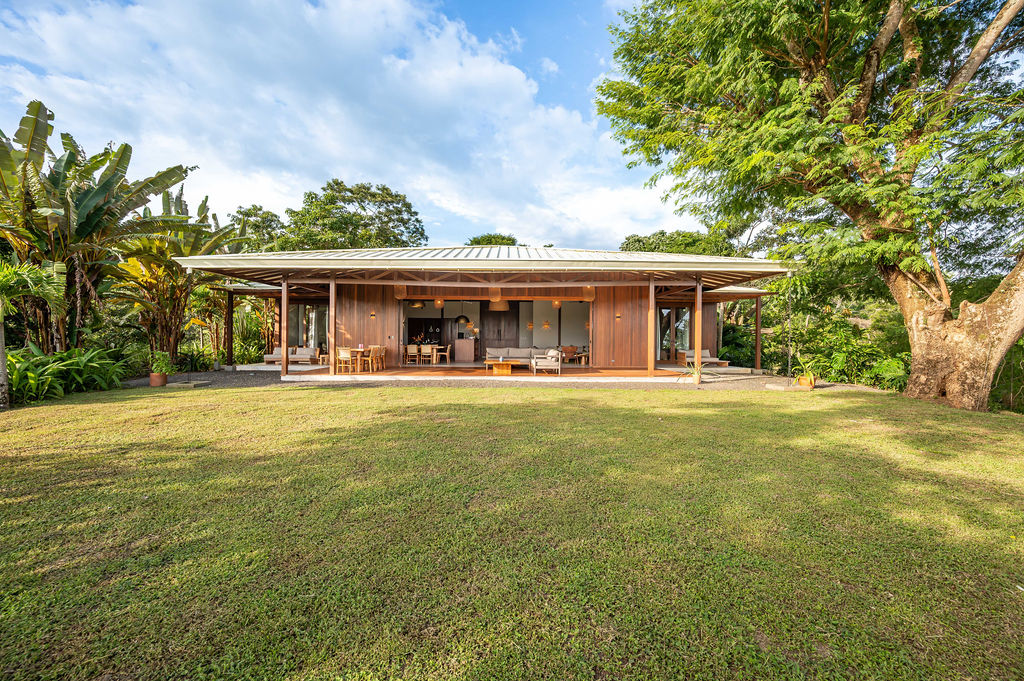 Front elevation of the main residence in timber and glass above an open lawn