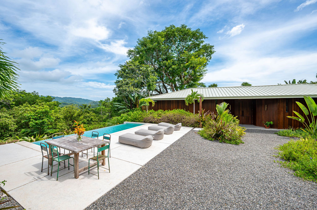 Infinity pool and sun deck with the timber-clad main residence beyond